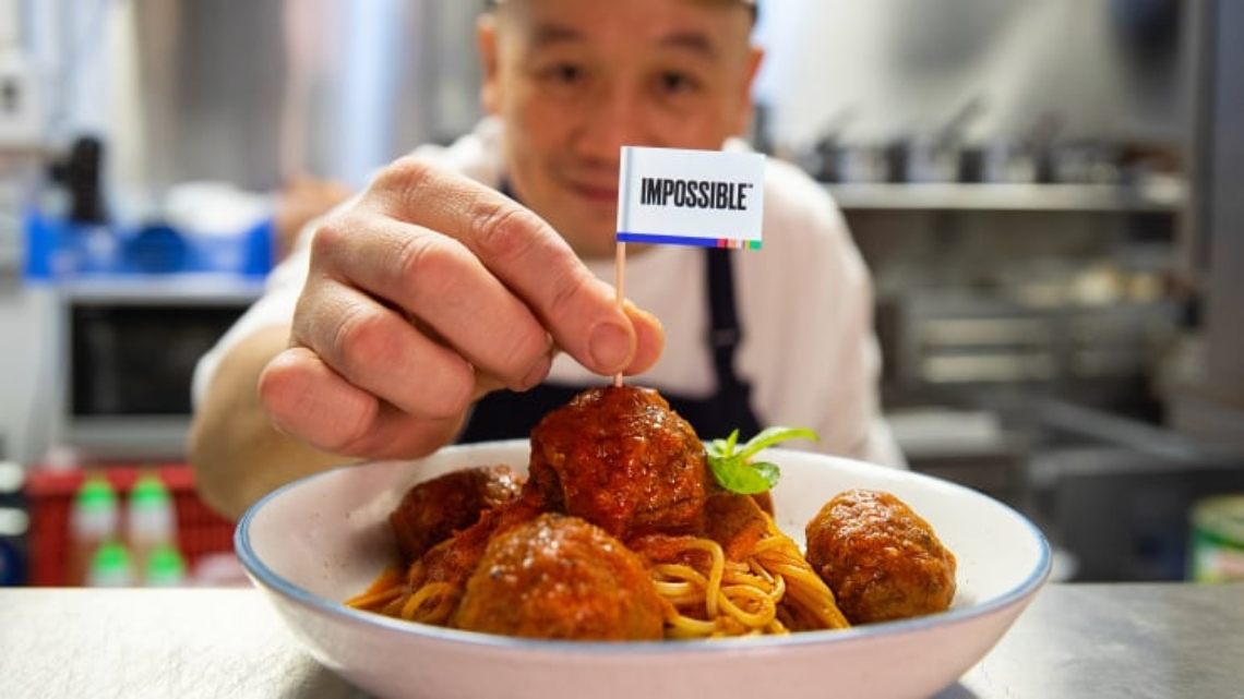 Chef with plate of Impossible Meatball Spaghetti